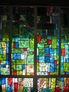 Winter season in stained glass along the chapel wall.